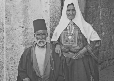 Älteres bethlehemitisches Ehepaar in ihrer traditionellen Kleidung vor ihrem Haus [1918-35, 122]